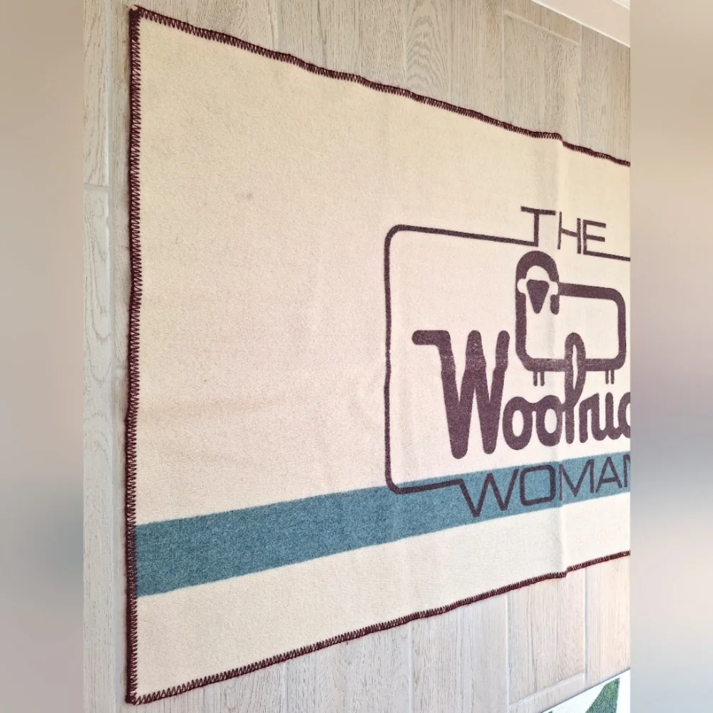The Woolrich Woman cream, brown and blue Woolrich sheep logo heavy wool blanket